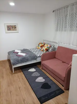 a living room with a bed and a couch at Apartma Juli in Žirovnica