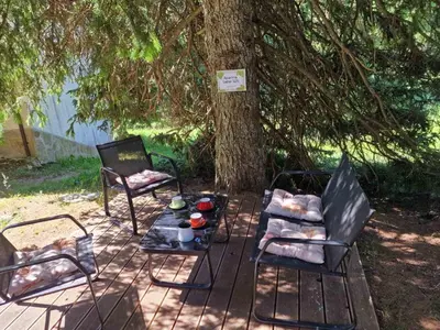 two chairs and a table under a tree at Apartma GABER 125 - Rogla in Zreče