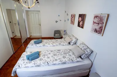 two beds in a room with a mirror at Central Living Vegova-with parking in Ljubljana