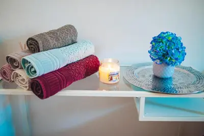a shelf with towels and a plate and a candle at Central Living Vegova-with parking in Ljubljana