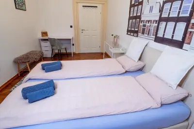 a room with two beds with blue pillows at Central Living Vegova-with parking in Ljubljana