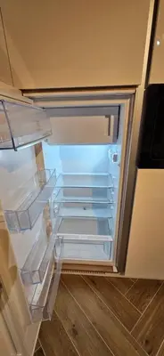 an empty refrigerator with its door open in a room at AppPrusnik in Ljubljana