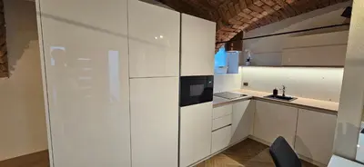 a kitchen with white cabinets and a black microwave at AppPrusnik in Ljubljana