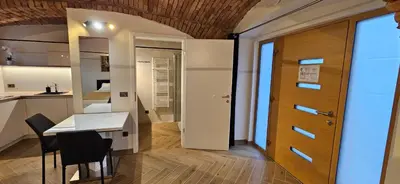 a room with a table and a door and a kitchen at AppPrusnik in Ljubljana