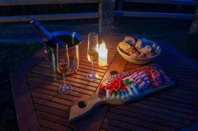 a picnic table with a bottle of wine and wine glasses at Holiday home in Trebelno - Dolenjska & Bela krajina Unter- & Weißkrain 26032 in Trebelno
