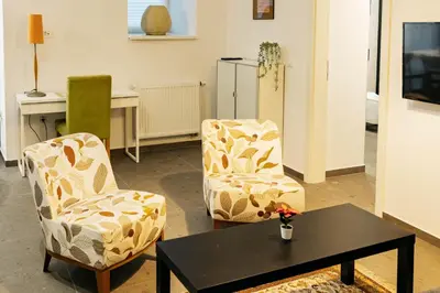 a living room with two chairs and a table at Vila Jakopič apartments in Ljubljana