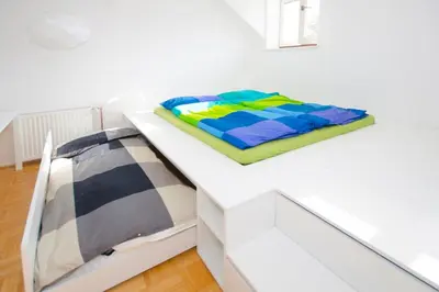 a bed on a white shelf in a room at The cute, sunny apartment in the center +P in Ljubljana