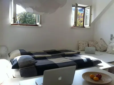 a bedroom with a bed and a table with a laptop at The cute, sunny apartment in the center +P in Ljubljana