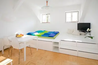 a room with a desk with a bed and a tv at The cute, sunny apartment in the center +P in Ljubljana