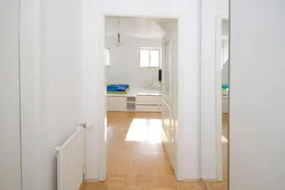 a hallway with white walls and a wooden floor at The cute, sunny apartment in the center +P in Ljubljana