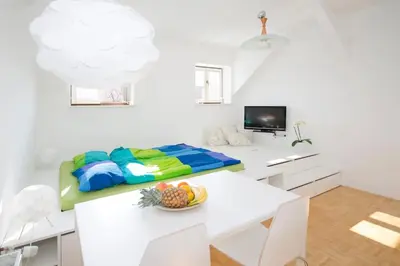 a white room with a table with a bowl of fruit on it at The cute, sunny apartment in the center +P in Ljubljana