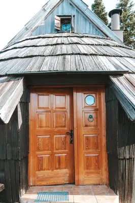 a wooden garage with a large wooden door at Velika planina - Chalet Stane - Alps in Stahovica