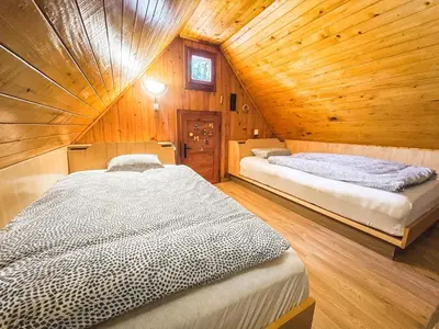 two beds in a room with a wooden ceiling at Velika planina - Chalet Stane - Alps in Stahovica