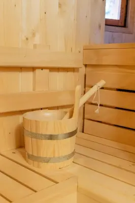 a wooden sauna with a wooden bucket in it at Velika planina - Chalet Stane - Alps in Stahovica