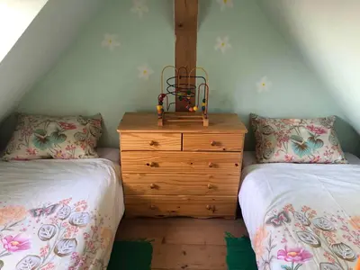 a bedroom with two beds and a wooden dresser at Holiday home in Srednje Grcevje - Kranjska Krain 26064 in Srednje Grčevje