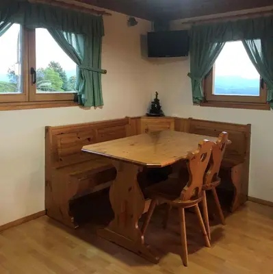 a wooden table and chairs in a room with two windows at Holiday home in Srednje Grcevje - Kranjska Krain 26064 in Srednje Grčevje