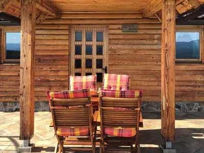 a patio with three chairs and a table in a cabin at Holiday home in Srednje Grcevje - Kranjska Krain 26064 in Srednje Grčevje