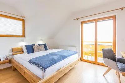 a bedroom with a large bed and a balcony at Vilaraj in Maribor