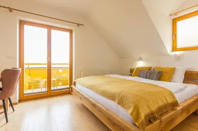 a bedroom with a large bed and a large window at Vilaraj in Maribor