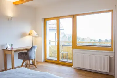 a bedroom with a bed and a desk and a window at Vilaraj in Maribor