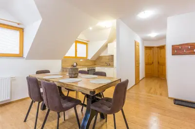 a kitchen and dining room with a wooden table and chairs at Vilaraj in Maribor