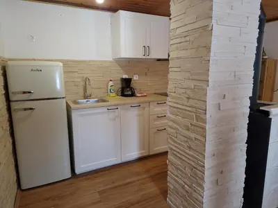 a kitchen with a white refrigerator and white cabinets at Triglav Cottage in Bohinj