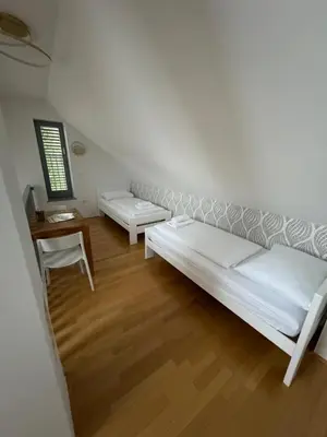 a white room with two beds and a table at Luxury Apartment Stilla in Bled