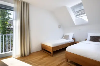 two beds in a room with a window at Luxury Apartment Stilla in Bled