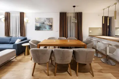 a living room with a wooden table and chairs at Luxury Apartment Stilla in Bled