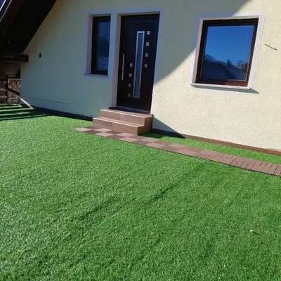 a yard with green grass next to a house at Apartmaji Biseri in Kranjska Gora
