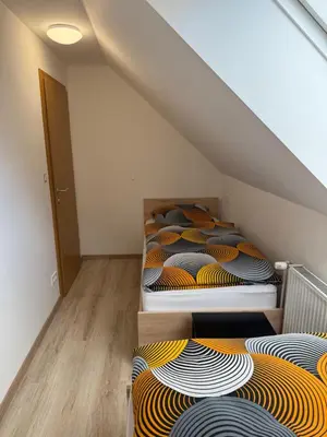 a attic room with three bunk beds in it at Apartmaji Biseri in Kranjska Gora