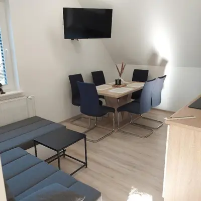 a dining room with a table and chairs and a tv at Apartmaji Biseri in Kranjska Gora