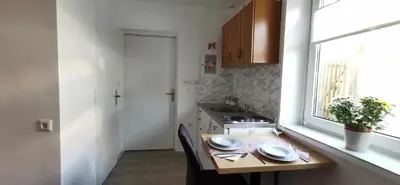a small kitchen with a table and a window at Apartma Lea in Slovenj Gradec