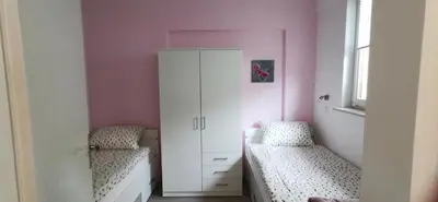 a bedroom with two beds and a white cabinet at Apartma Lea in Slovenj Gradec