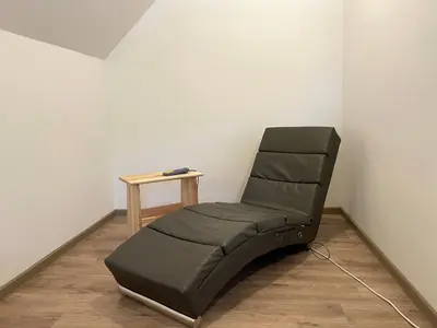 a leather chair in a corner with a table at Apartment House Prezlc in Kranjska Gora