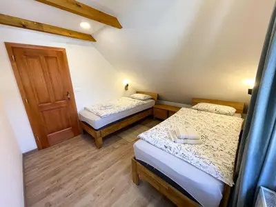 a small room with two beds and a door at Apartment House Prezlc in Kranjska Gora