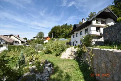a white house with a garden in front of it at apartmaji LEJARDIN in Škofljica