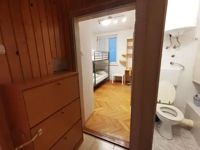 a bathroom with a toilet and a room with a bedroom at Apartment for four with free parking in Ljubljana