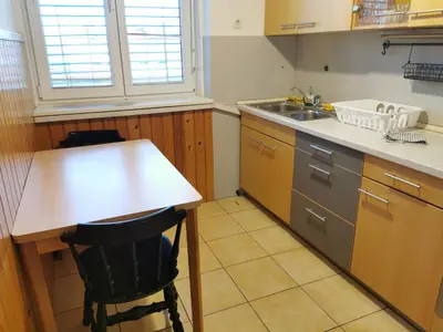a kitchen with a counter and a table and a sink at Apartment for four with free parking in Ljubljana