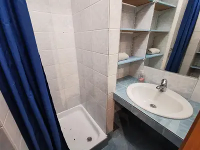a bathroom with a sink and a toilet and a mirror at Apartment for four with free parking in Ljubljana