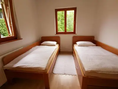two beds in a room with two windows at Soča House with a View - Lepena valley in Soča
