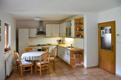 a kitchen and dining room with a table and chairs at Soča House with a View - Lepena valley in Soča