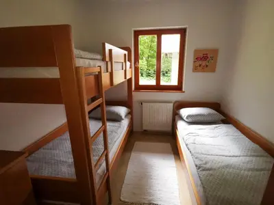a small room with two bunk beds and a window at Soča House with a View - Lepena valley in Soča