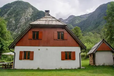 a large house with windows and mountains in the background at Soča House with a View - Lepena valley in Soča