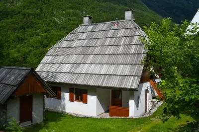 an old white house with a metal roof at Soča House with a View - Lepena valley in Soča