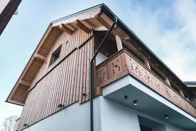 a building with a balcony on top of it at Podlipnik Apartments in Kranjska Gora
