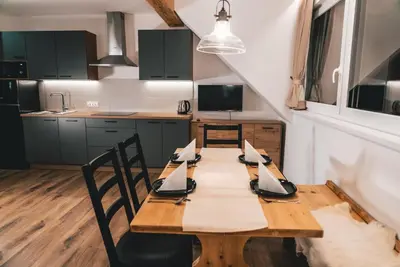 a kitchen with a wooden table with napkins on it at Podlipnik Apartments in Kranjska Gora