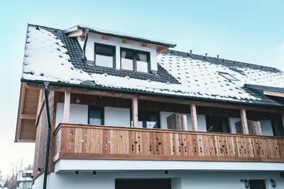 a house with a snow covered roof at Podlipnik Apartments in Kranjska Gora