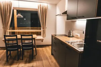 a kitchen with a table and chairs and a sink at Podlipnik Apartments in Kranjska Gora