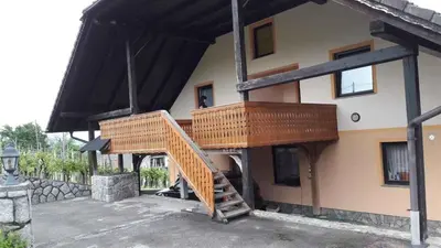 a house with a wooden staircase on the side of it at Houses and Apt in Smarjeske Toplice Kranjska Krain 26042 in Smarjeske Toplice